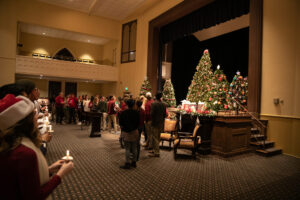 Christmas trees on stage in an auditorium.