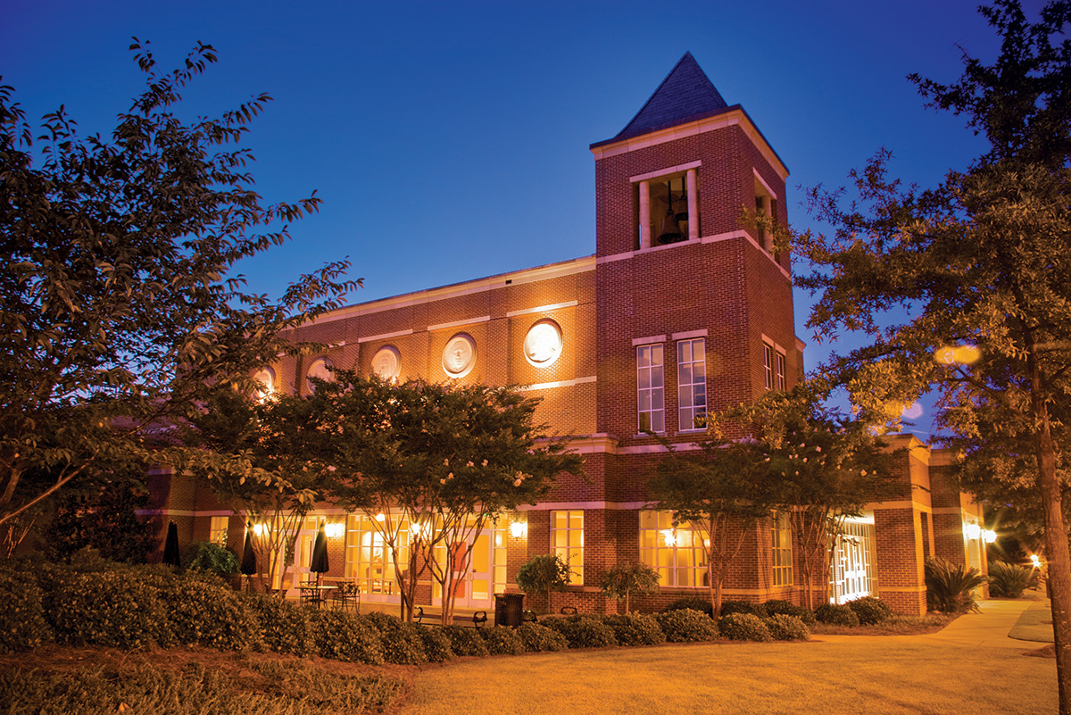 Exterior view of the McCorkle Music Building, a stately brick building, at night.