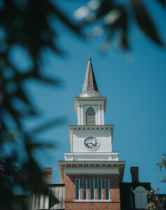 Willingham Hall clock tower against blue sky.