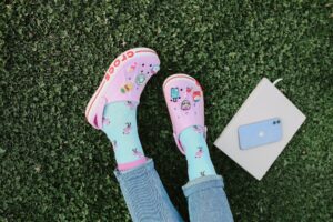 Overhead Shot of a Person's Legs and feet wearing crocs Near a Notebook