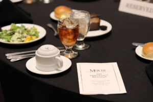 food on a table alongside a program that says mercer university 2022 emeriti faculty recognition