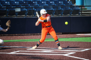softball player prepares to swing at ball