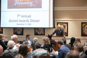 mercer president william d. underwood stands behind a podium and speaks to a group of seated people