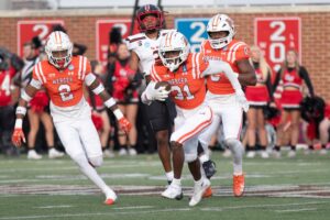 A football game in progress featuring Mercer players in orange and white uniforms.