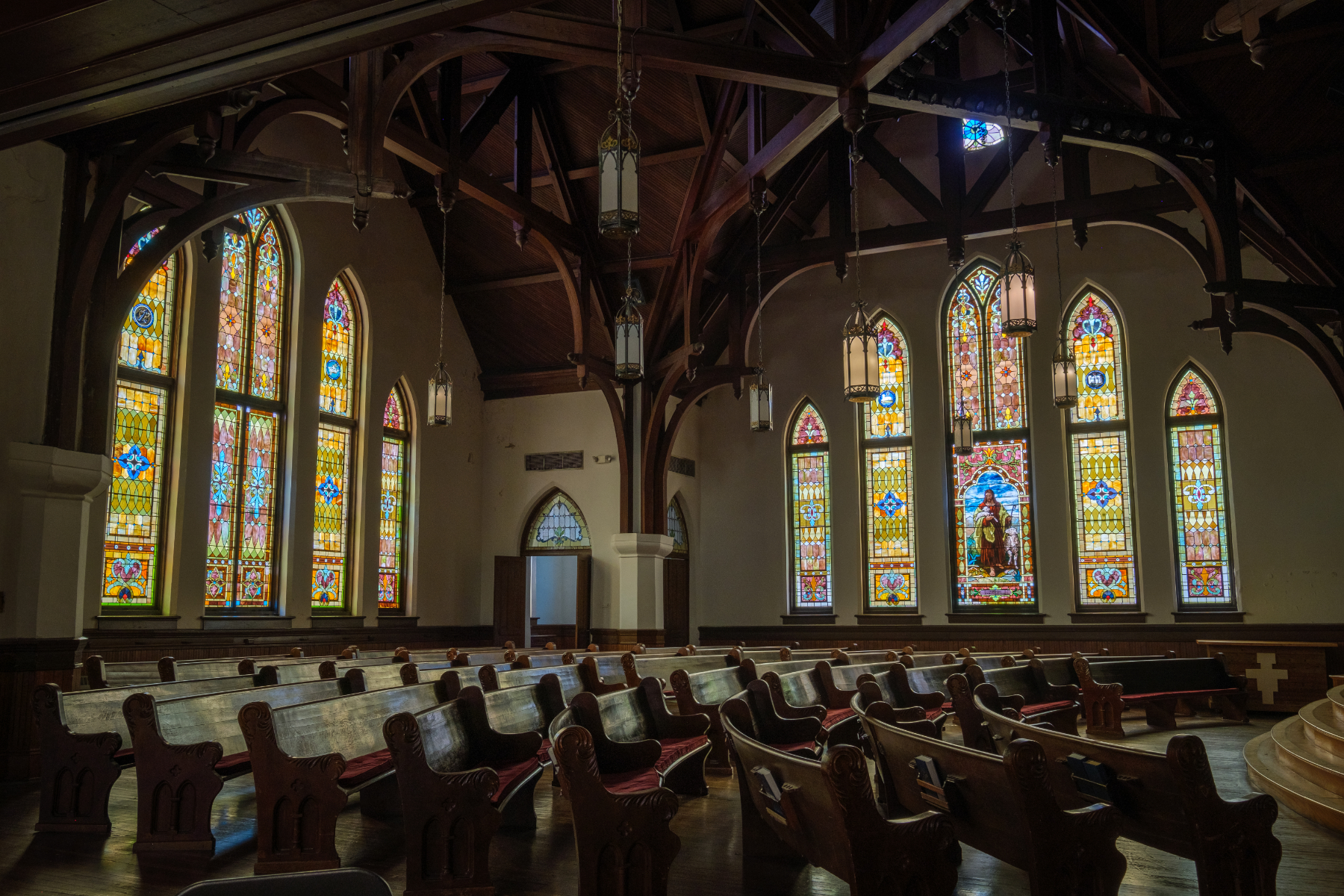 Interior of Newton Chapel featuring pews and large stained glass windows.