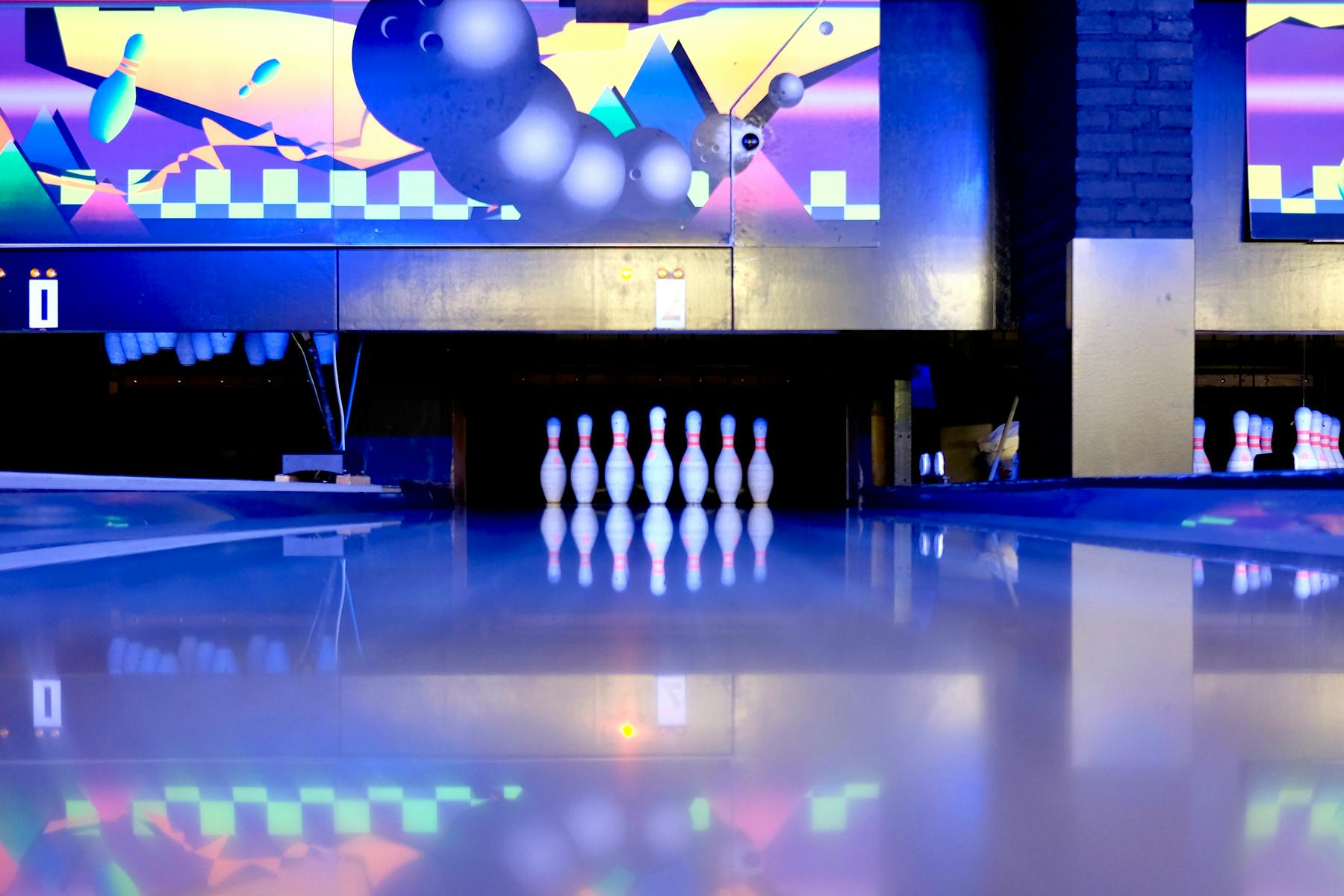 Bowling pins set at the end of a lane in a bowling alley.