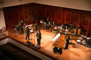 Overview of a concert hall with various percussion instruments and musicians performing.