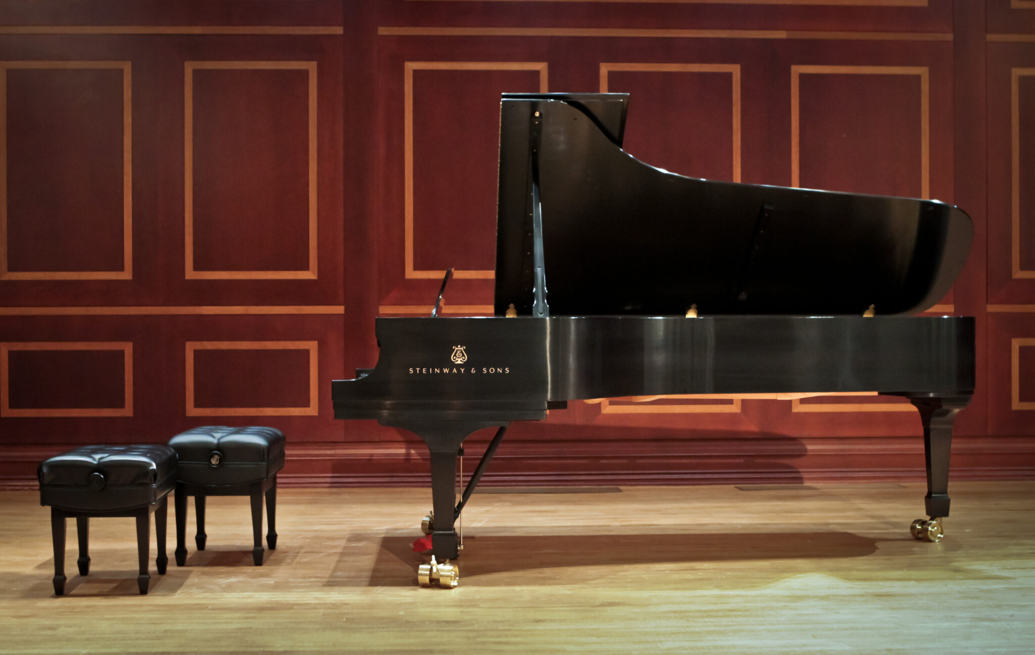 A grand piano sits on a stage.