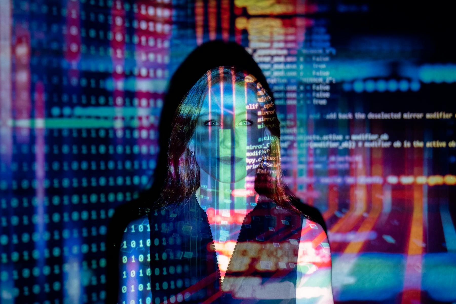 Computer code projected over an image of a woman