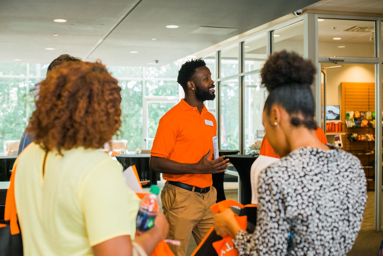 A Mercer staff members talks to a group of prospective working adult students.