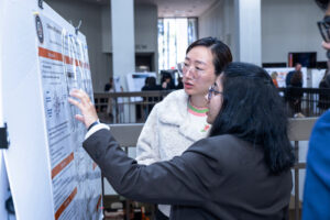 Two Mercer students examine a poster at the 2024 Atlanta Research Conference.