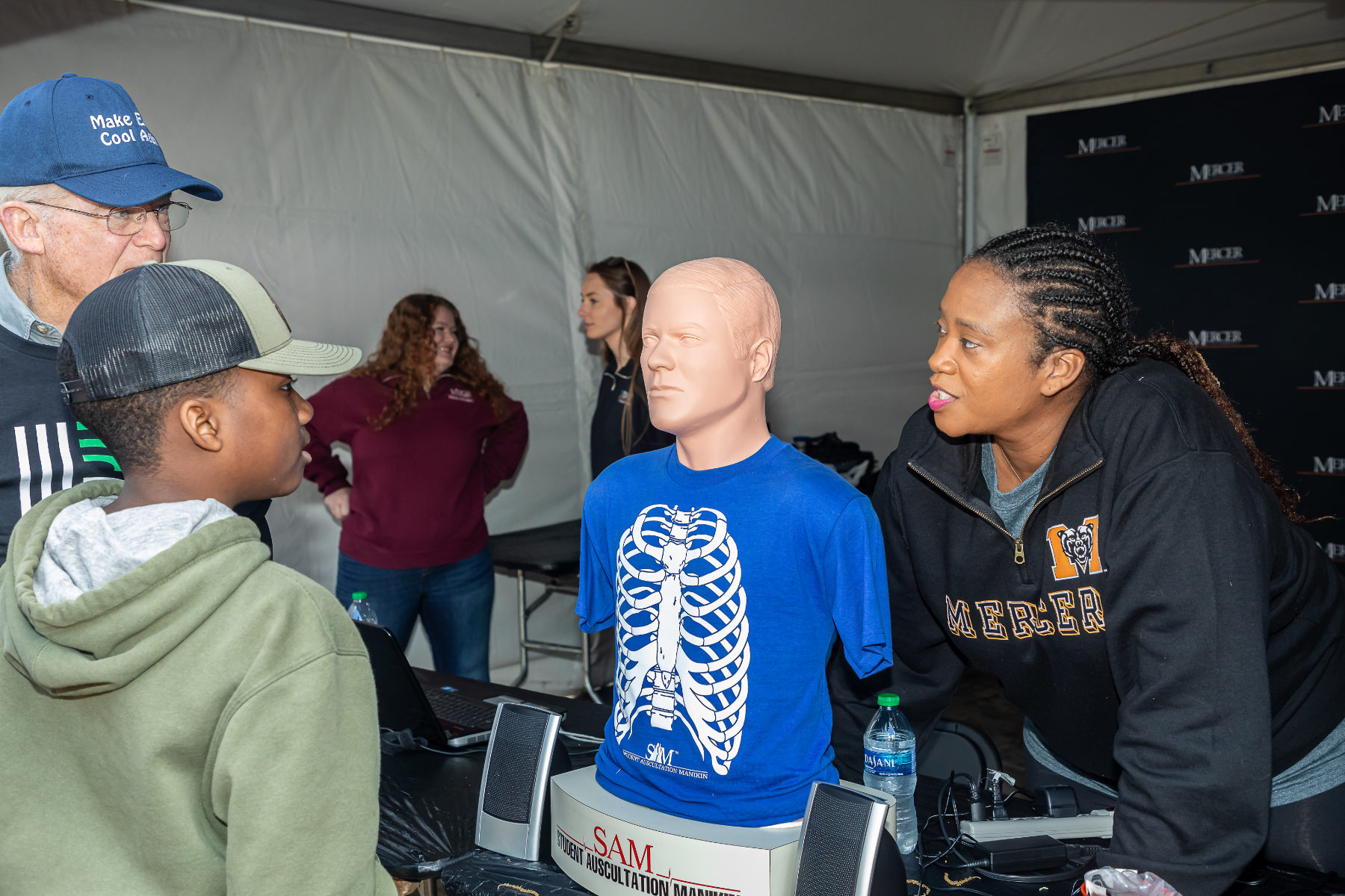 A Mercer student shows off a student auscultation manikin to Atlanta Science Festival visitors.