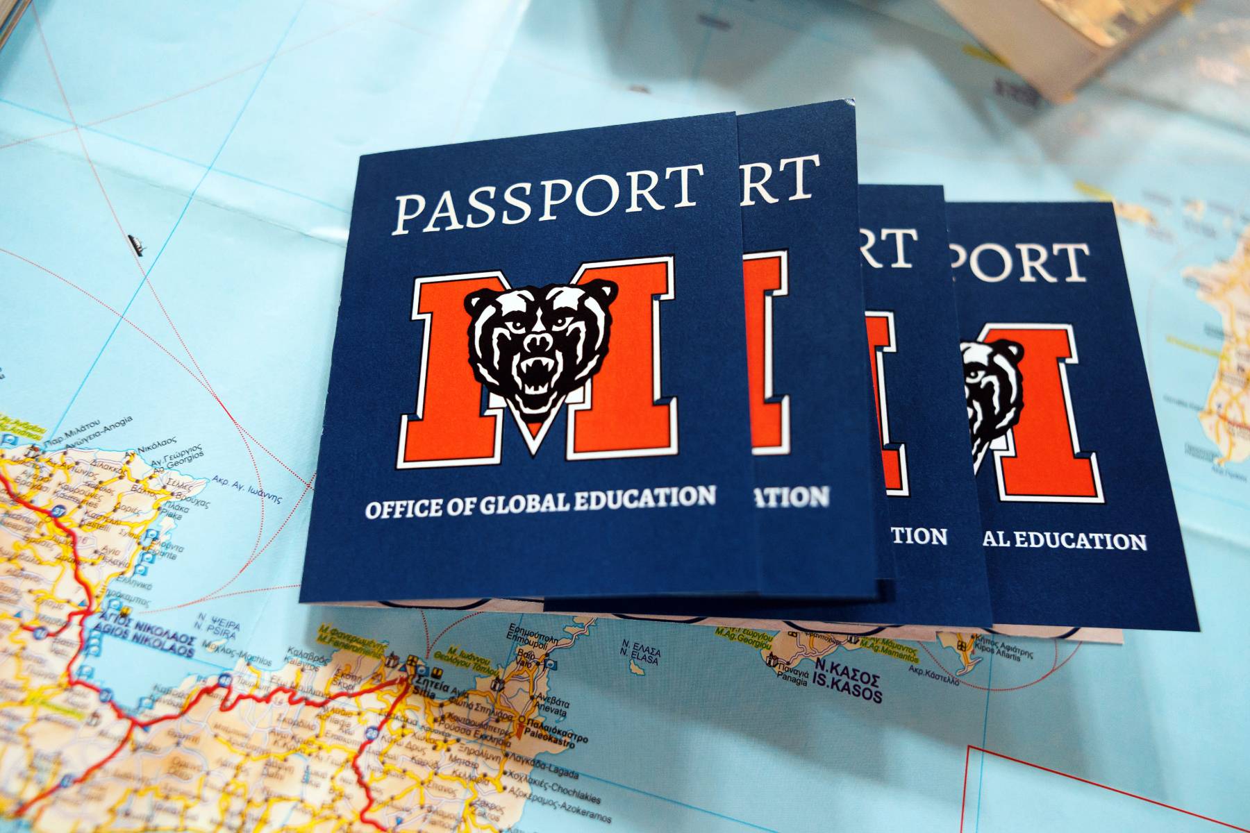 Four passports featuring the Mercer M set on a map.