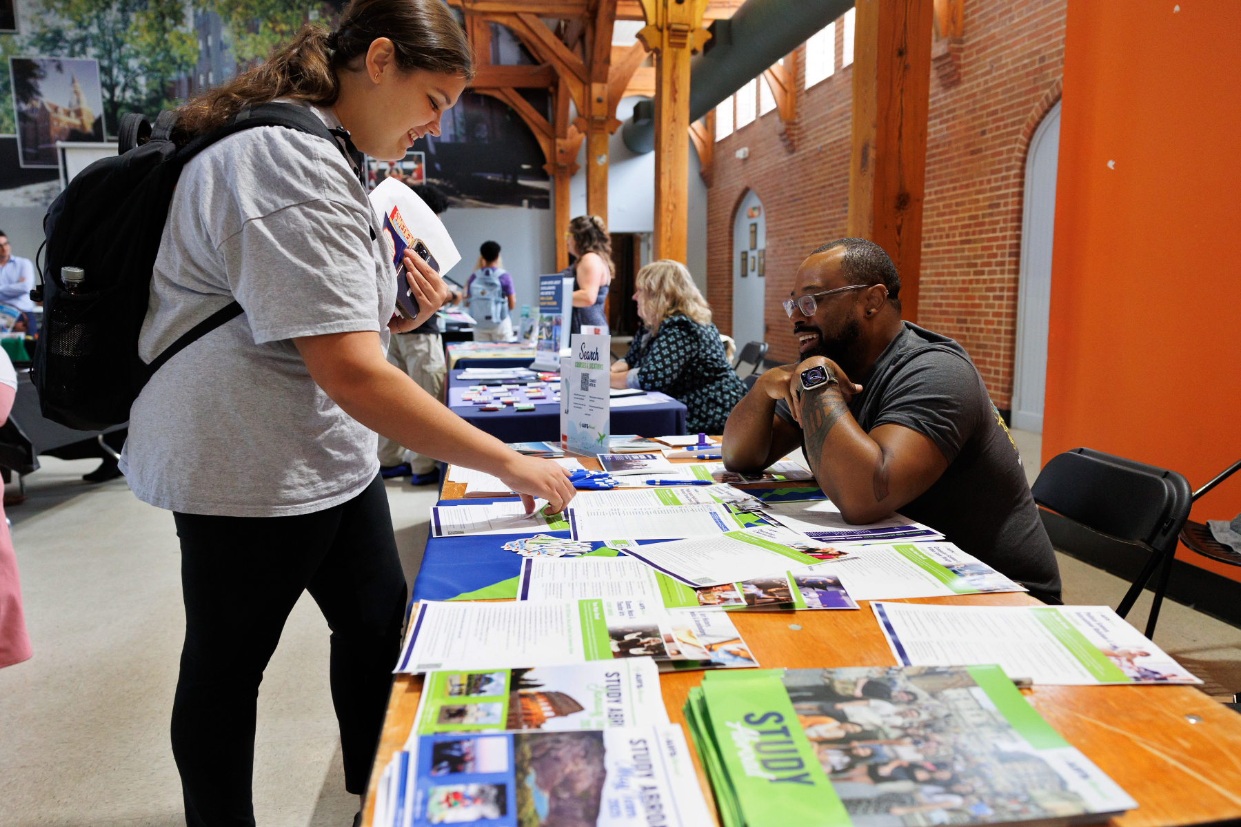 A Mercer student looks at a table covered in brochures and flyers about study abroad.