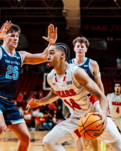 A Mercer men's basketball player avoids a block by the other team during a game.