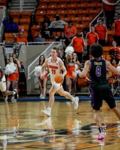 A Mercer men's basketball player dribbles the ball during a game.