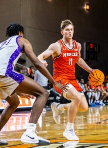 A Mercer men's basktball player dribbles the ball during a game.