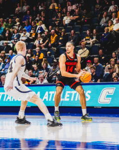 A Mercer men's basketball player looks to pass the ball during a game.
