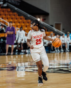 A Mercer women's basketball player dribbles the ball during a game.