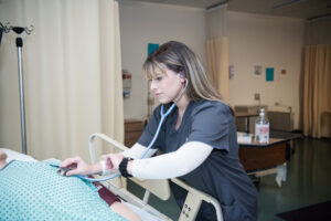 A nursing student uses a stethoscope.