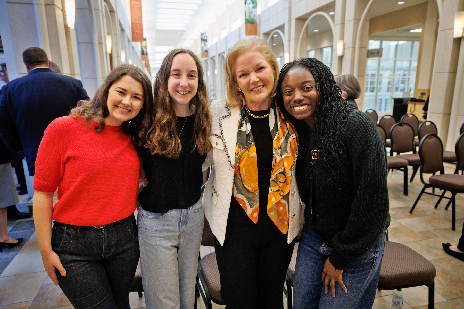 Mercer President Dr. Penny L. Elkins stands smiling with three students.