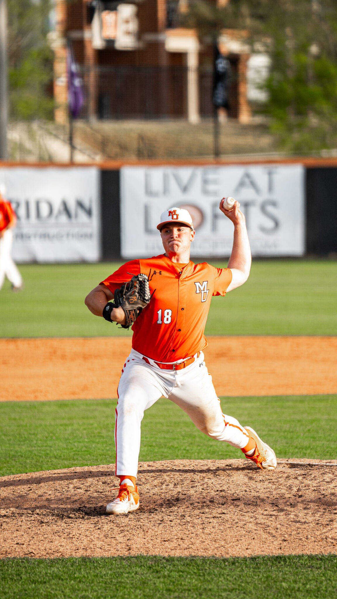 A Mercer baseball pitcher prepares to throw a pitch on a baseball field during a game.