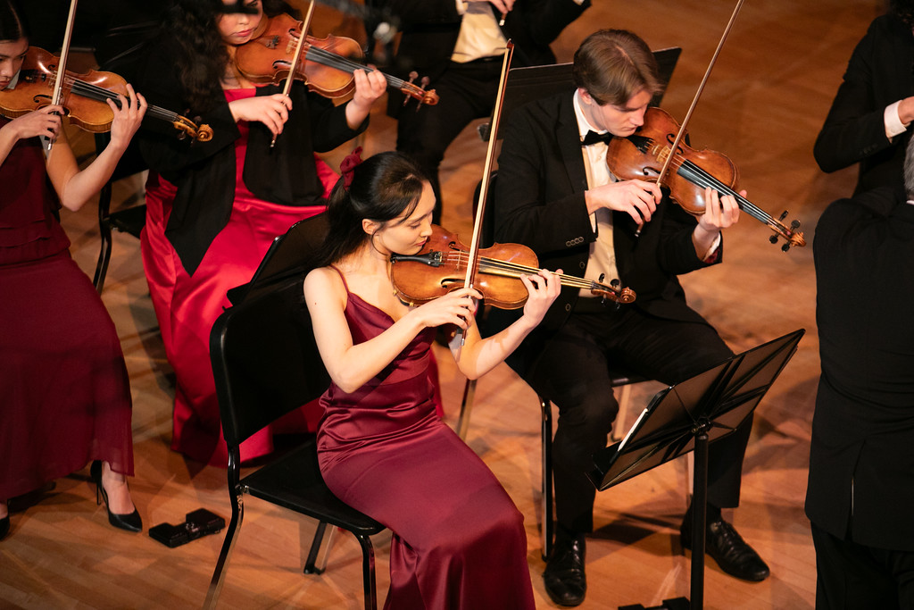 Strings musicians perform on stage.