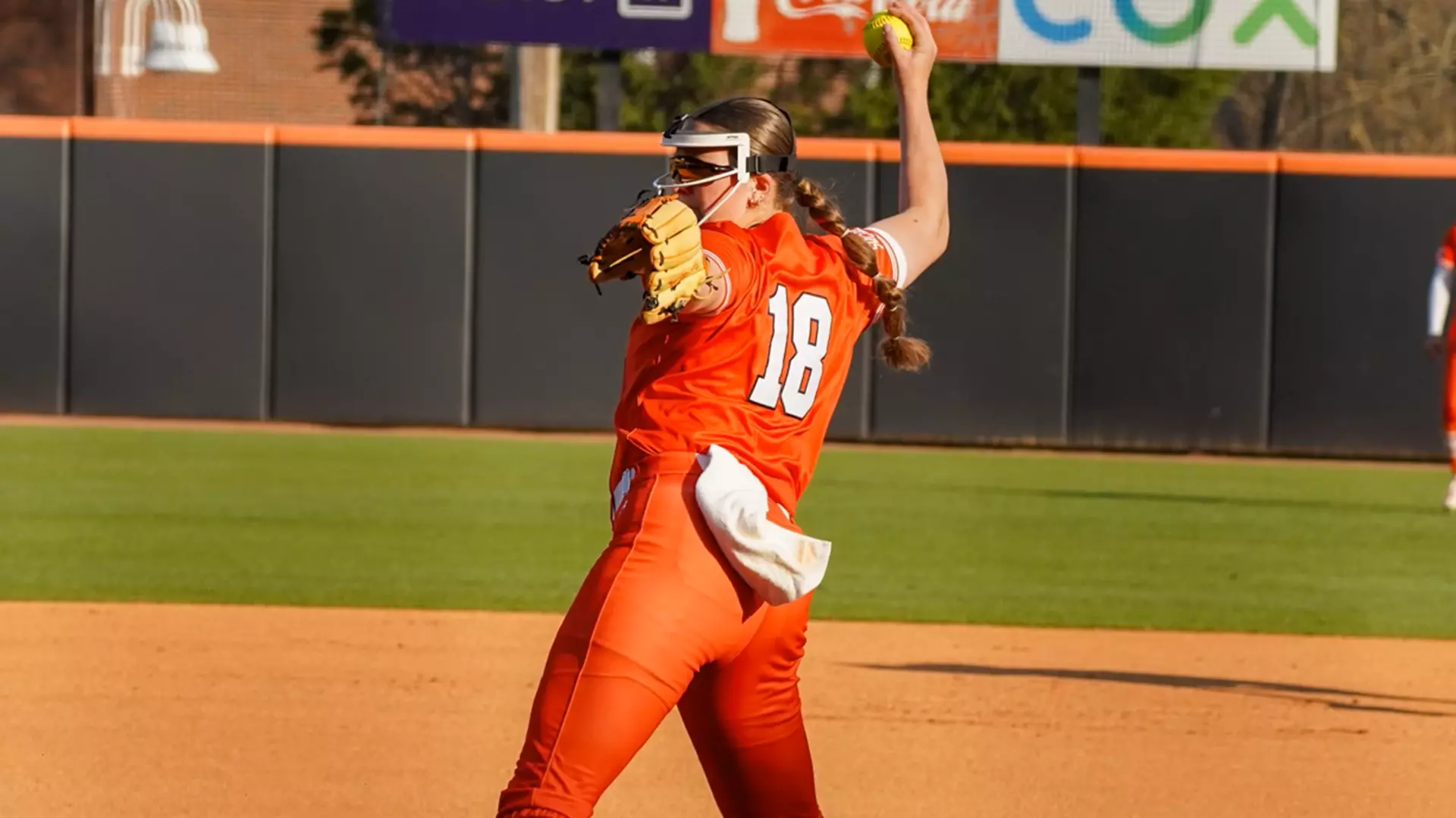 Mercer softball pitcher winds up to throw on a sunny outdoor field.