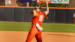 Mercer softball pitcher winds up to throw on a sunny outdoor field.