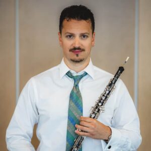 Isaac Ripple holding an oboe.