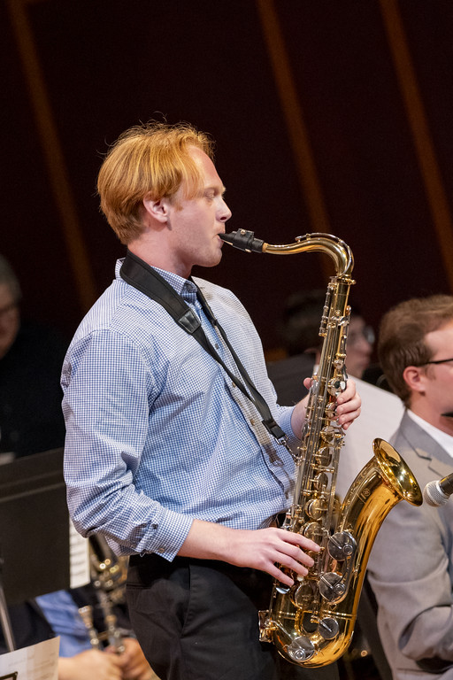 A musician plays the saxophone on stage.