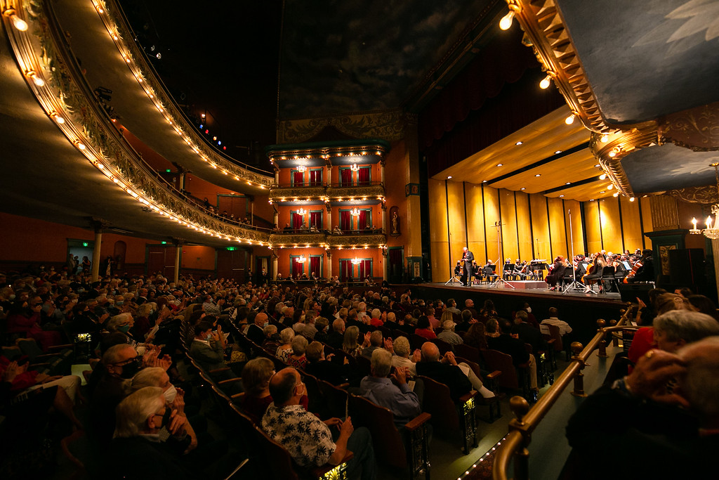 A full audience watches the Macon-Mercer Symphony Orchestra perform on stage at The Grand Opera House.