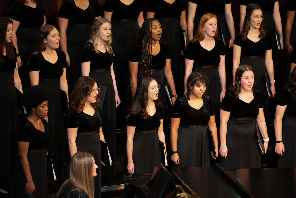 Women's choir performs on stage.