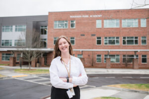 A woman stands in front of a school.