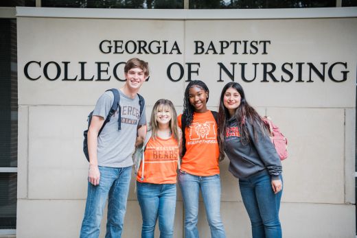 Students stand in front of a Georgia Baptist College of Nursing sign.