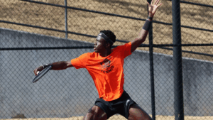 Mercer men's tennis player prepares to hit a backhand shot on an outdoor court.