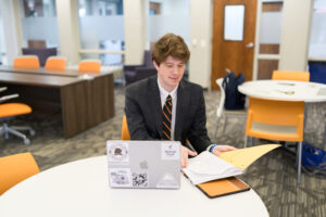 A business student works at a computer on a table.