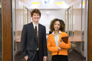 Two Mercer students in business attire stand inside the Mercer Innovation Center.