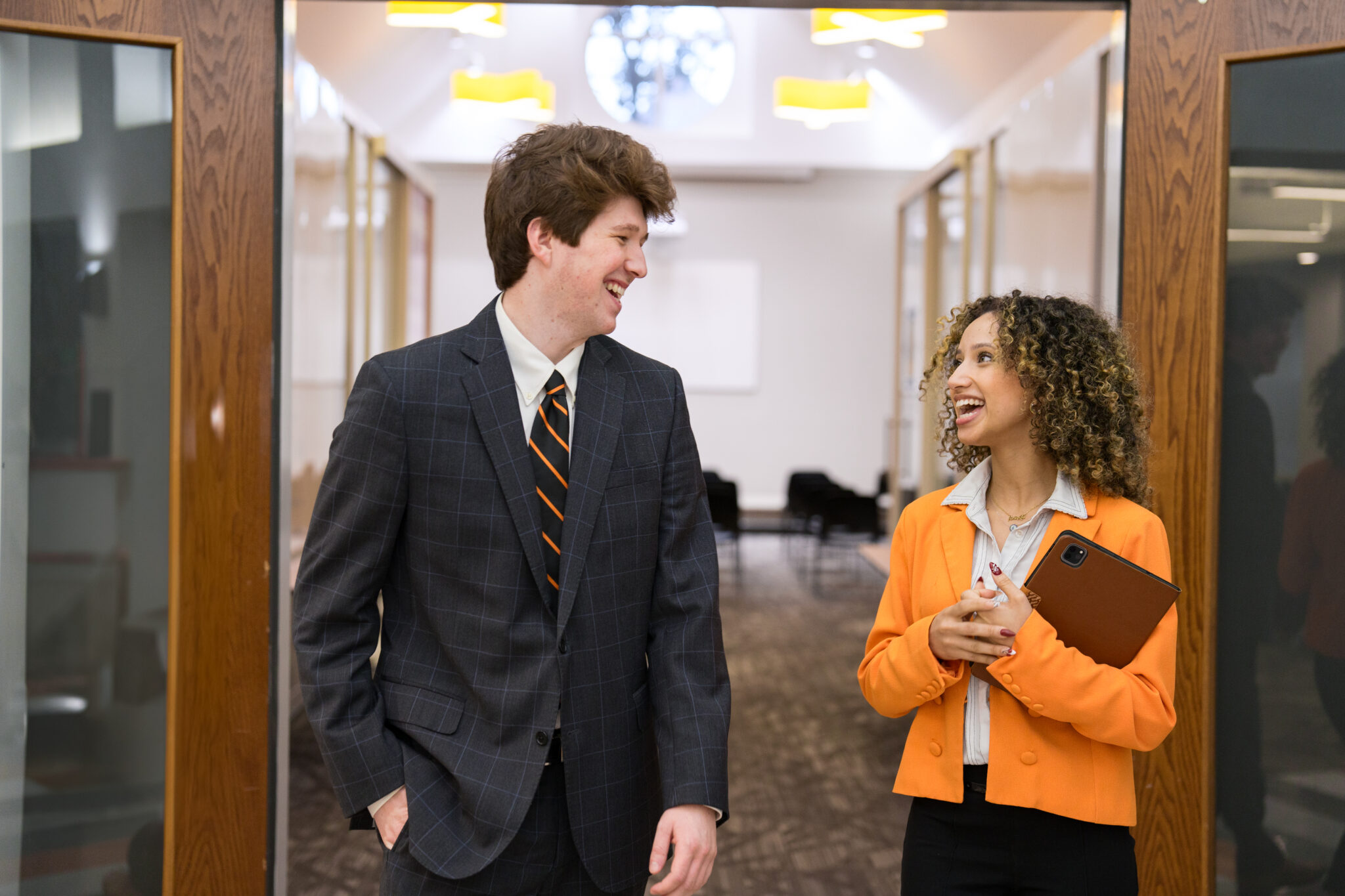 Two Mercer students in business attire stand inside the Mercer Innovation Center.