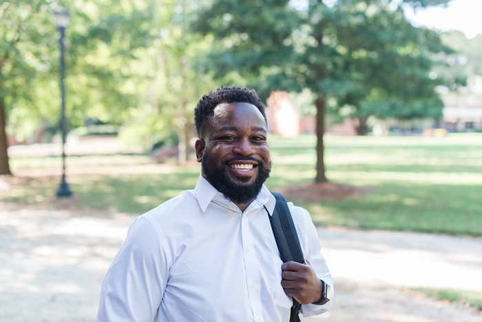 A student with a backpack slung over one shoulder standing on the Mercer campus.