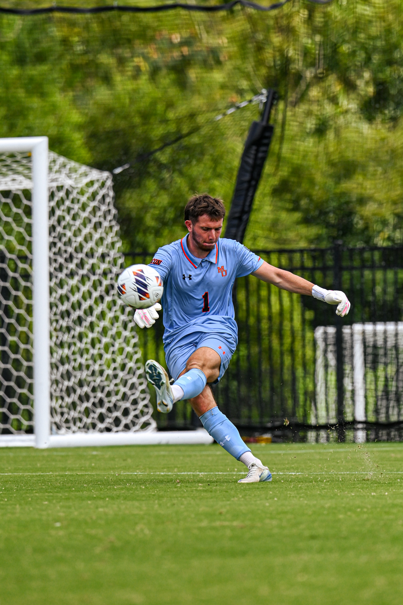 A Mercer goalkeeper punts the ball from the goal box during a match.