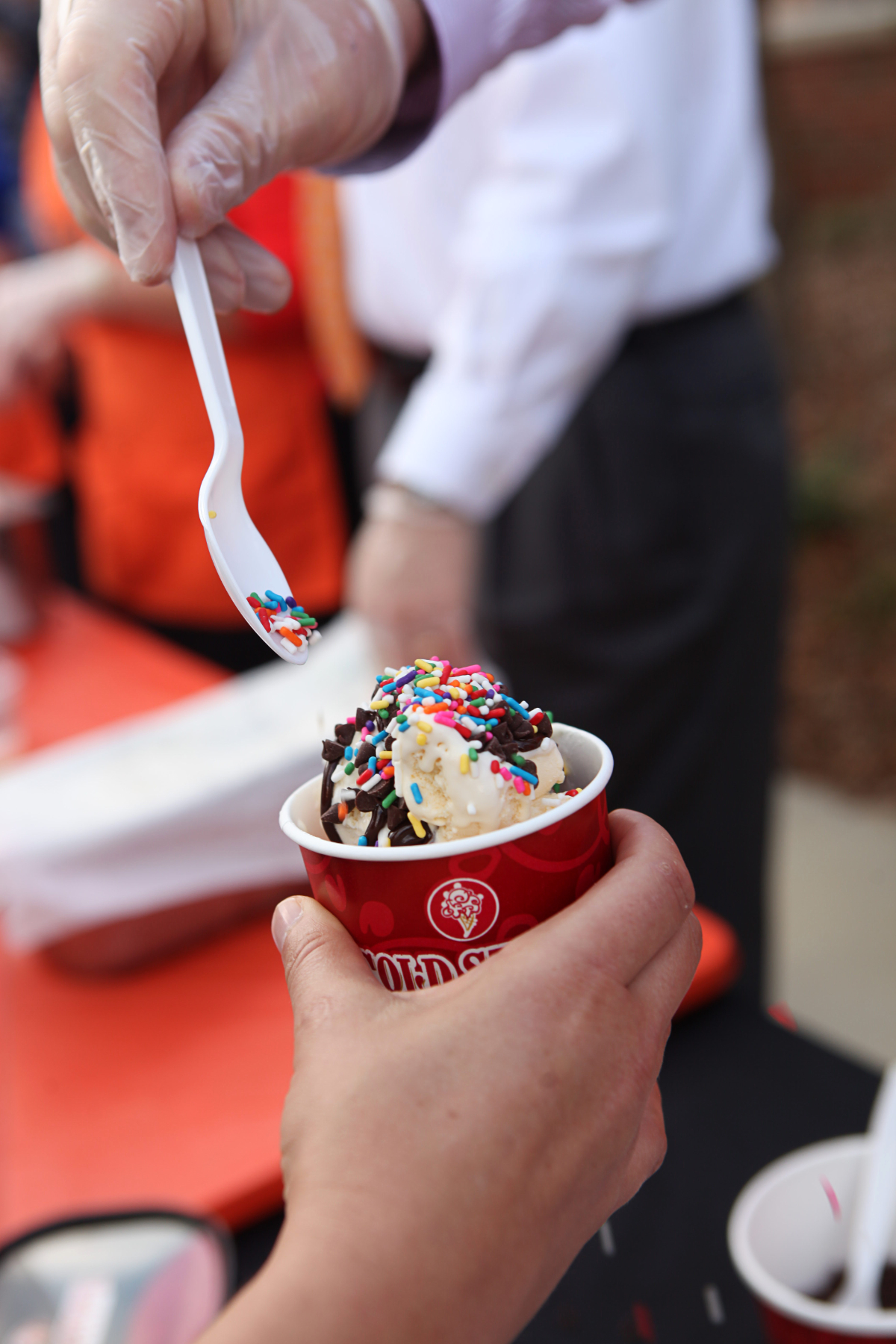 A hand holds a cup of ice cream.