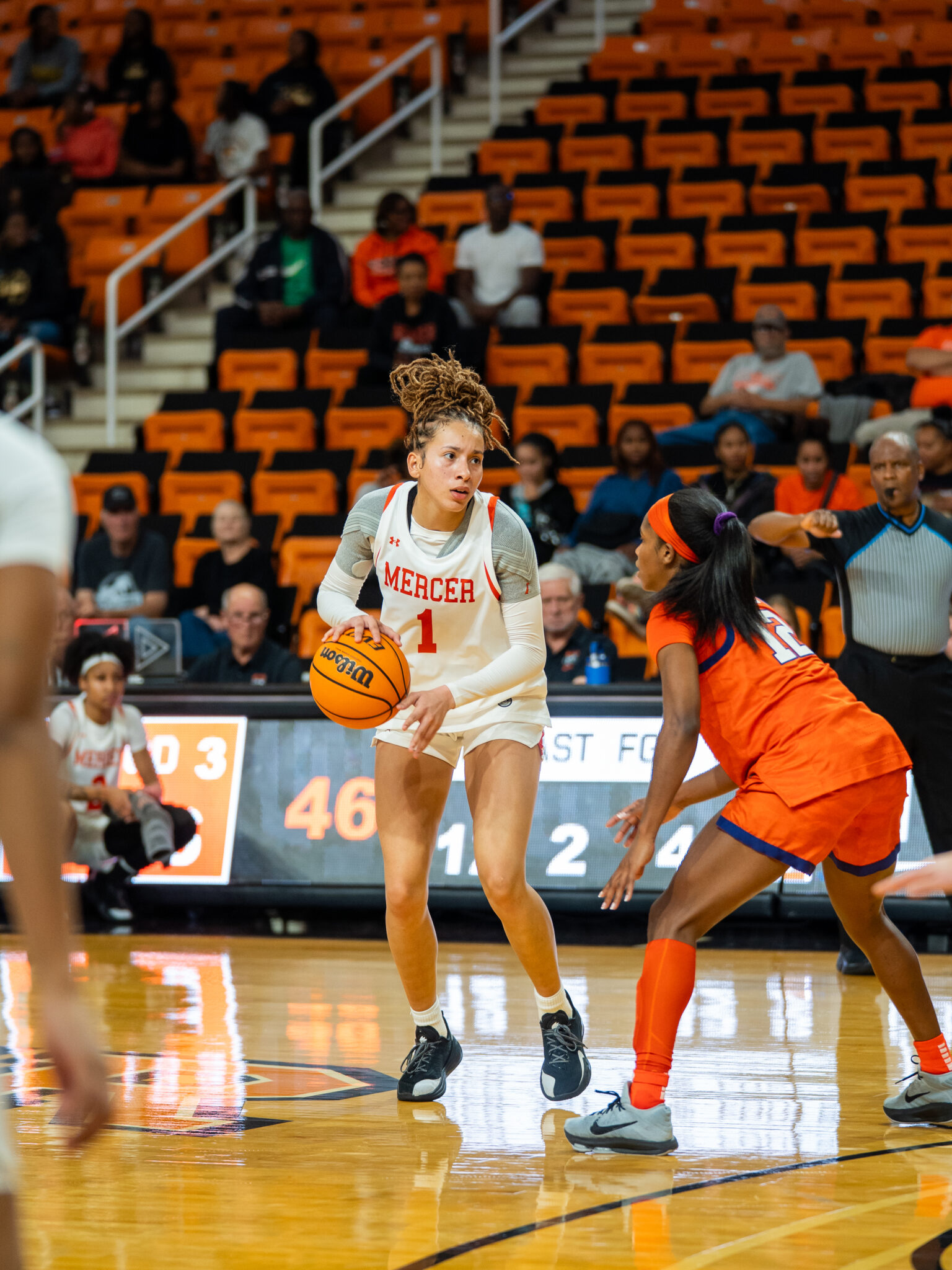 A Mercer women's basketball player dribbles the ball during a game.
