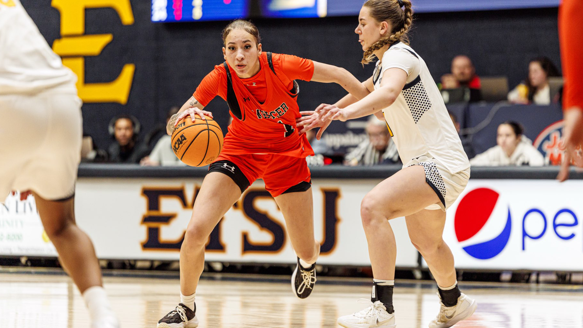 A Mercer women's basketball players dribbles the ball during a game.